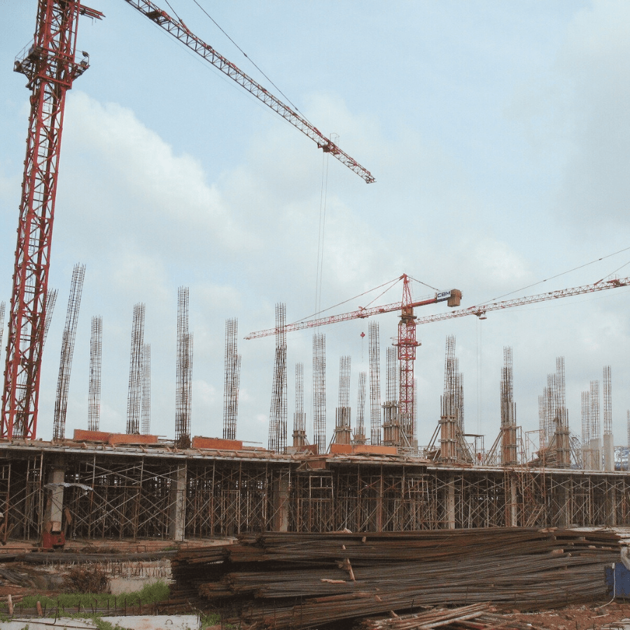 Macarale turn roșii pe șantier clădire cu armături verticale – Nomade Construction