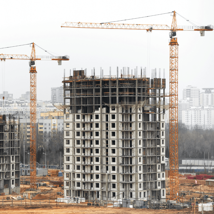 Clădire turn în construcție cu macarale portocalii – Nomade Construction